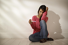 Young woman looking down at a pregnancy test